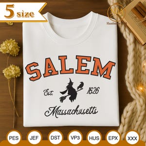May include: White sweatshirt with the word "SALEM" in orange block letters. Below the word is a black silhouette of a witch on a broom with a raven. The text "Est. 1626 Massachusetts" is also on the shirt.