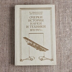 Peut inclure: Un livre vintage avec une couverture beige. La couverture présente du texte en russe et une illustration d'un avion ancien. Le titre se lit « Essais sur l'histoire des sciences et de la technologie 1870-1917 ». La couverture a une bordure décorative.