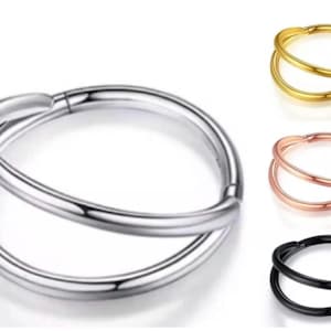 May include: A silver double hoop nose ring. Other rings in gold, rose gold, and black are also shown. The jewellery has a smooth, polished finish. The design features two interlocking hoops.