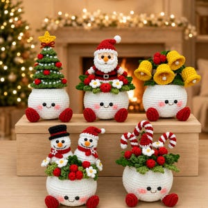 May include: Five crocheted plush figures with white round bases, red feet, and smiling faces. The figures feature a green Christmas tree, a Santa Claus, yellow bells, two snowmen, and candy canes, all decorated with red berries and white flowers.