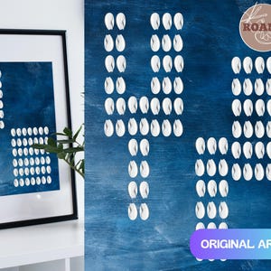 Puede incluir: Pieza de arte abstracto con un lienzo enmarcado y un panel de arte mural. El arte enmarcado presenta pinceladas blancas sobre un fondo azul. El panel de arte mural tiene pinceladas blancas dispuestas en un patrón. El texto "ORIGINAL ART" es visible.