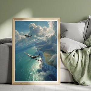 May include: A framed print showing fighter planes in flight over a coastal scene. The artwork features a dramatic sky with clouds, a turquoise sea, and white cliffs. The planes are painted in green, grey, and red. The image is framed in a light wood.