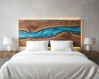 May include: A wooden headboard with a blue resin river design, illuminated by a warm light. The headboard is above a bed with white bedding and two matching bedside tables with lamps.