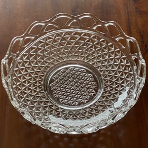 May include: Clear glass serving bowl with a diamond pattern and a decorative, scalloped edge. The bowl has a circular center and is designed for serving food. The glass is transparent, allowing the contents to be visible.