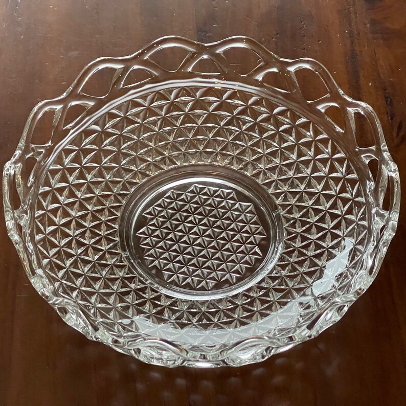 May include: Clear glass serving bowl with a diamond pattern and a decorative, scalloped edge. The bowl has a circular center and is designed for serving food. The glass is transparent, allowing the contents to be visible.