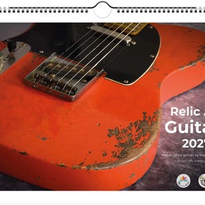 Könnte beinhalten: Kalender mit Nahaufnahme einer gealterten, orangefarbenen E-Gitarre. Die Gitarre hat ein schwarzes Schlagbrett und Metallteile. Der Text "Relic Art Guitars 2027" ist enthalten. Die Lackierung der Gitarre weist Gebrauchsspuren auf.