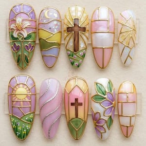 May include: A collection of ten artificial nails, each adorned with a unique stained-glass effect design. The nails showcase various motifs such as flowers, crosses, and geometric shapes, all framed with gold. The colour scheme incorporates soft pastels and bright shades.