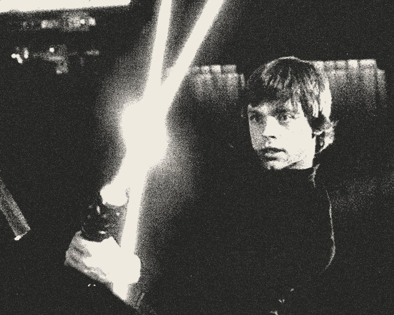 K&ouml;nnte beinhalten: Ein Schwarzwei&szlig;foto eines jungen Mannes, der ein Lichtschwert h&auml;lt. Das Lichtschwert ist eingeschaltet und das Licht leuchtet hell. Der Mann schaut zur Seite und hat einen ernsten Gesichtsausdruck.
