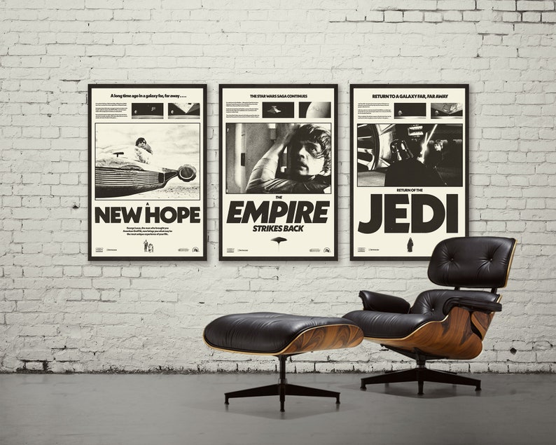 K&ouml;nnte beinhalten: Drei schwarz-wei&szlig;e Star Wars-Filmplakate in schwarzen Rahmen, die an einer wei&szlig;en Backsteinwand h&auml;ngen. Die Poster sind f&uuml;r Star Wars: Eine neue Hoffnung, Das Imperium schl&auml;gt zur&uuml;ck und Die R&uuml;ckkehr der Jedi. Ein schwarzer Ledersessel mit Holzsockel und einem passenden Hocker stehen vor den Postern.