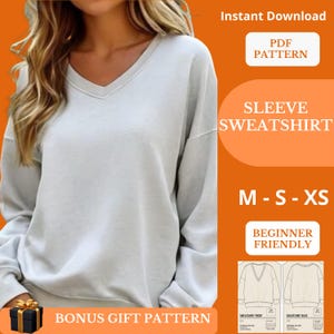 Puede incluir: Una sudadera gris claro con cuello en V. La imagen incluye el texto "Descarga instantánea", "PDF PATTERN", "SLEEVE SWEATSHIRT", "M - S - XS" y "BEGINNER FRIENDLY". También se incluye un patrón de regalo adicional.