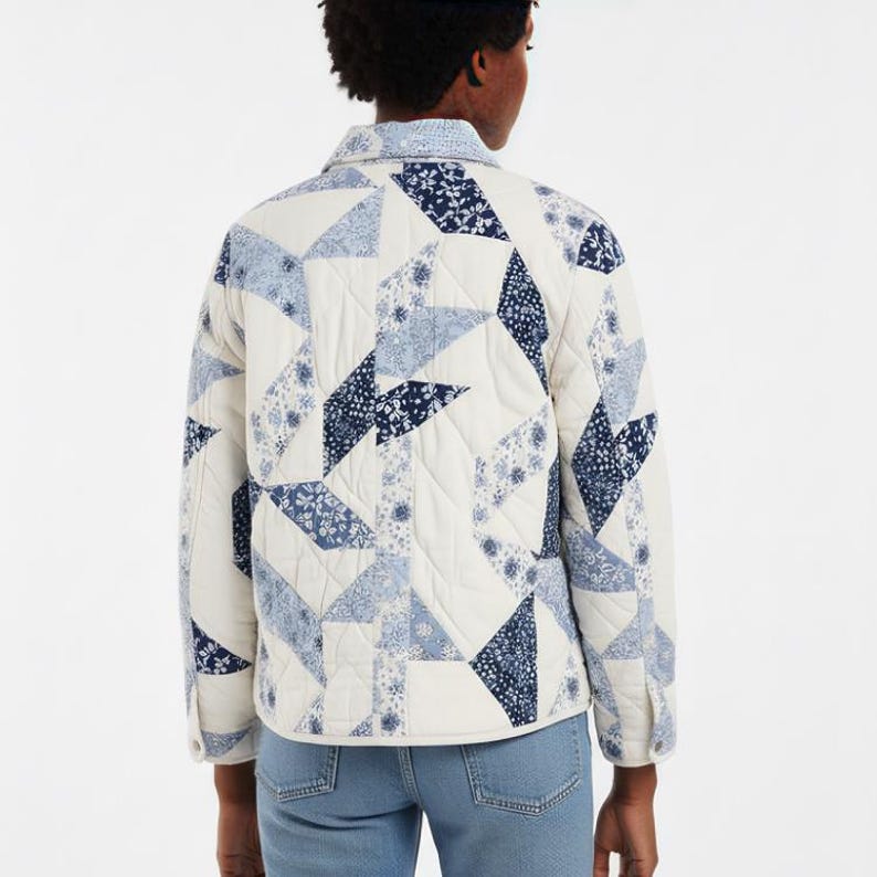 May include: A quilted jacket with a patchwork design in white, light blue, and navy. The jacket has a collared neckline, long sleeves, and button closures. The geometric pattern includes floral and solid shapes.
