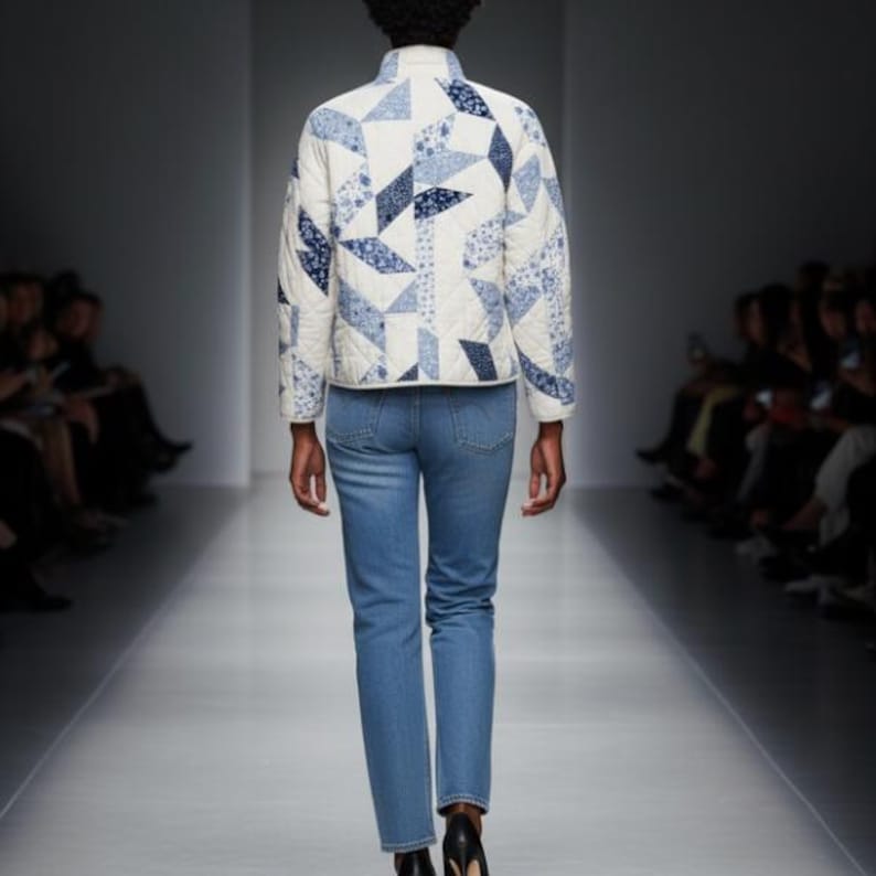 May include: A quilted jacket with a geometric pattern in shades of blue and white, paired with light blue jeans. The jacket features a stand-up collar and a quilted design. The model is walking on a runway.