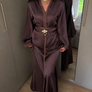 Eenvoudige Marokkaanse kaftan van zijde met riem en broche.