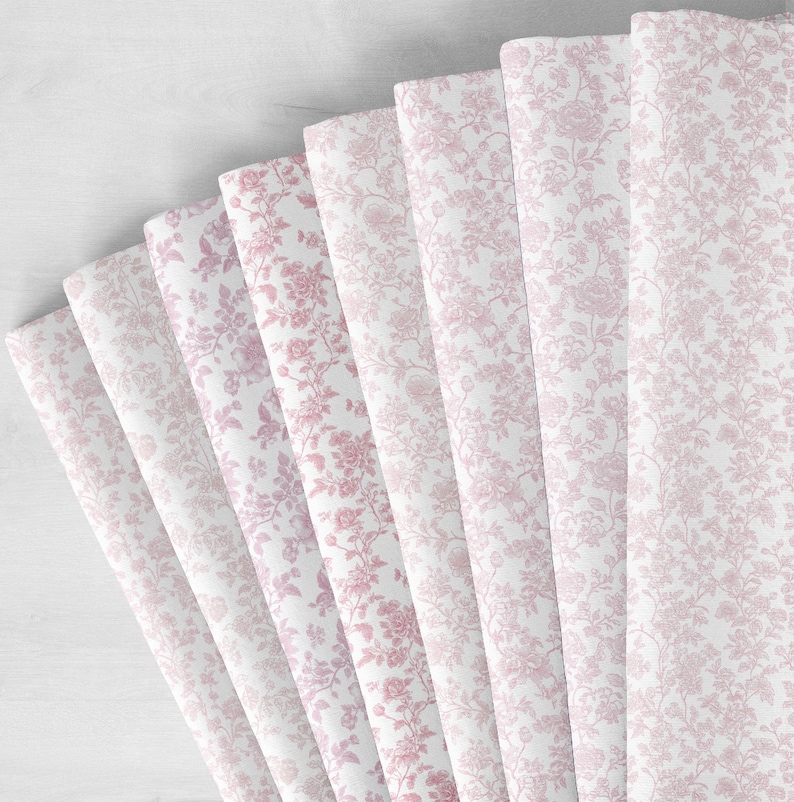 May include: A collection of folded fabric samples featuring a delicate floral pattern in varying shades of pink and white. The fabric has a classic, vintage aesthetic, with a repeating design of roses and other flowers.