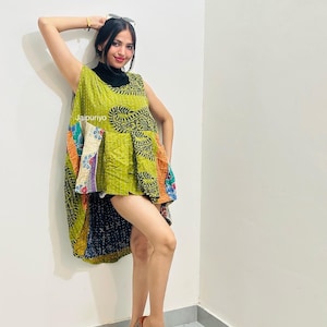 May include: A sleeveless tunic top featuring a patchwork design with a prominent lime green base, black paisley patterns, and multi-colored floral accents. The garment includes the text Jaipuriyo printed on the front and has a high-low hemline.
