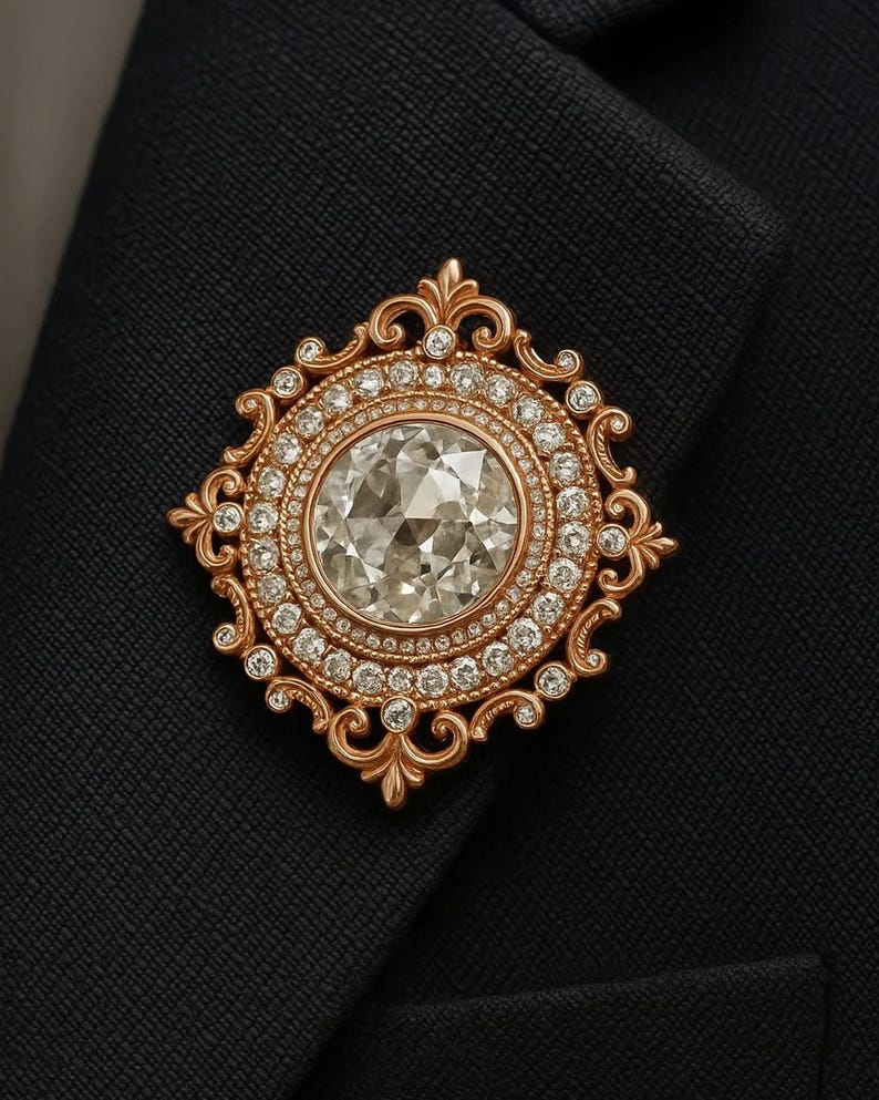 Puede incluir: Broche dorada con un gran diamante central rodeado de diamantes m&aacute;s peque&ntilde;os. La broche tiene un dise&ntilde;o ornamental de filigrana y est&aacute; colocada sobre una tela azul oscuro.