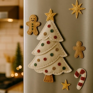 May include: Felt Christmas tree magnet with colourful dot ornaments, a star topper, and gingerbread man magnets. Additional star and candy cane magnets complete the festive holiday decor. The magnets are attached to a stainless steel fridge.