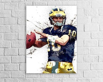 May include: Artwork of a football player in a navy blue and gold uniform, throwing a football. The player wears a gold helmet and the number 10 is visible on the jersey. The artwork has a watercolour effect with paint splatters.