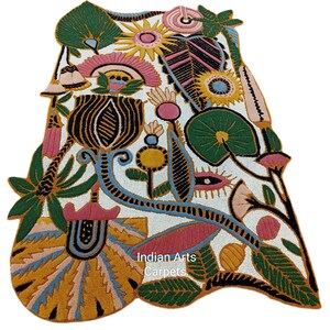May include: A colorful, floral-patterned rug with a white background. The rug features a variety of flowers and leaves in shades of green, pink, yellow, and blue. The text "Indian Arts Carpets" is visible on the rug.