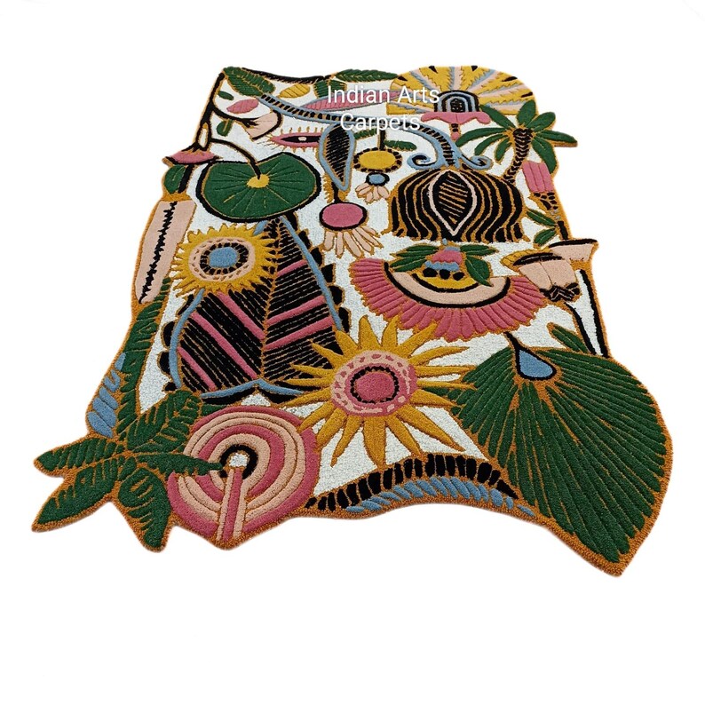 May include: A colorful, floral-patterned rug with a white background. The rug features various embroidered flowers and leaves in shades of pink, yellow, green, and blue. The text "Indian Arts Carpets" is visible on the rug.