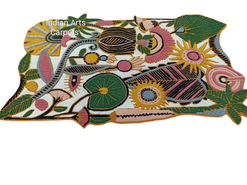 May include: A colorful, floral-patterned rug with a white background. The rug features various flowers and leaves in shades of pink, yellow, green, and black. The text "Indian Arts Carpets" is visible in the upper left corner.
