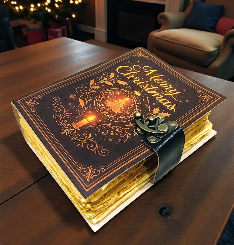 May include: A decorative Christmas journal with a dark brown cover featuring the words "Merry Christmas" in gold script. The cover design includes a Christmas tree and candle illustration. The journal is secured with a black leather strap and metal clasp.