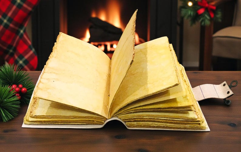 May include: An open, aged-looking book with yellowed pages sits on a dark wooden surface. The book's pages are slightly curled, and a leather bookmark extends from the spine. A fireplace and Christmas decorations are in the background.