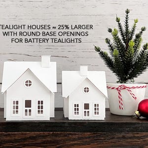 Puede incluir: Dos casas de papel blanco con aberturas redondas en la base, dise&ntilde;adas para velas de t&eacute; a pilas. El texto de la imagen dice "Tealight Houses ~ 25% Larger with Round Base Openings for Battery Tealights".