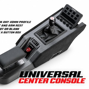 May include: A black universal center console for racing simulators featuring a gear shifter with a black boot, a padded armrest, a red ignition button, and a top-mounted button box. The unit includes text stating it installs on any 40mm profile.