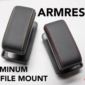 Puede incluir: Dos reposabrazos negros con monturas de perfil de aluminio. Un reposabrazos tiene costuras amarillas, el otro costuras rojas. La palabra "ARMREST" está impresa encima de los reposabrazos, y "ALUMINUM PROFILE MOUNT" está impresa debajo.