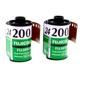 May include: Two rolls of Fujifilm Fujicolor 200 film. The film canisters are white with black and green labels. The text "24 200" is prominently displayed. The film is for color processing.