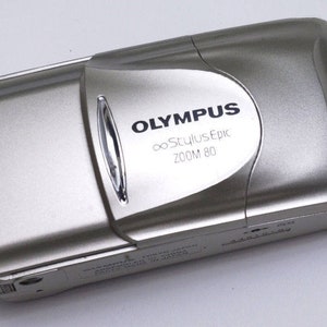 Silver Olympus camera lens cover