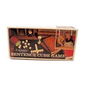 May include: A vintage Scrabble Sentence Cube Game box. The box features a retro design with the game's name prominently displayed. The box shows a couple playing the game, along with game pieces and a dice cup.