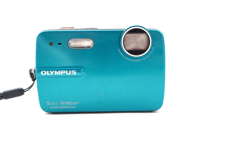 May include: A teal Olympus Stylus Water 3m/10ft waterproof digital camera with a black strap.