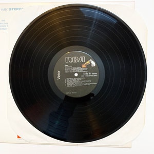 May include: Black vinyl record with a white label. The label has the RCA logo, the title "Hair", and the text "Side B Stereo LSO 1150 (WPRS-30630)".