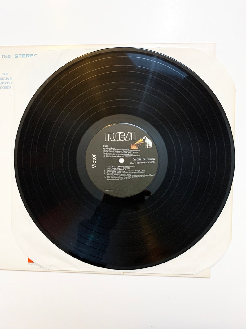 May include: Black vinyl record with a white label. The label has the RCA logo, the title "Hair", and the text "Side B Stereo LSO 1150 (WPRS-30630)".