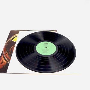May include: A black vinyl record with a green label. The label has the text "Rolling Stones" and the album title "Some Girls".