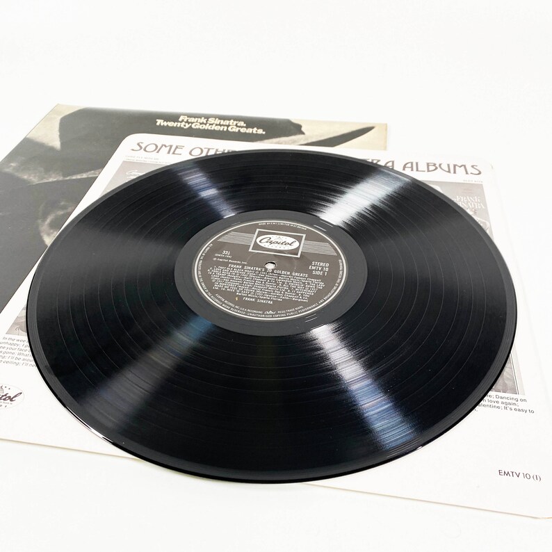 May include: Black vinyl record with a white label featuring Frank Sinatra's "Twenty Golden Greats" album. The label has the Capitol Records logo and the album title in black text.