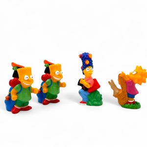 May include: Four Simpsons character figurines. Two Bart figures wear green shirts, red shoes, and blue backpacks. Marge plays an accordion, and Lisa plays a saxophone. All figures are on a white background.