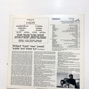 May include: A vintage vinyl record cover for the musical "Hair" featuring the original Broadway cast. The cover is a vibrant yellow with black text and a photo of three men. The text includes the title "Hair", the names of the cast members, and the song titles from the album.