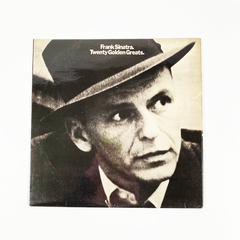 May include: Black and white photo of Frank Sinatra on a record album cover. The album title is "Frank Sinatra. Twenty Golden Greats."