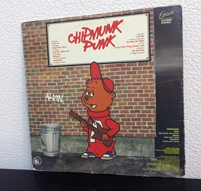 May include: A vintage vinyl record album cover featuring Alvin the Chipmunk playing a red electric guitar. The album is titled "Chipmunk Punk" and features a brick wall background with the text "Crazy Little Thing Called Love" and "My Sharona".