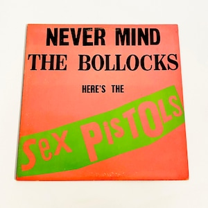 May include: A pink and green vinyl record album cover with the text "Never Mind The Bollocks Here's The Sex Pistols".