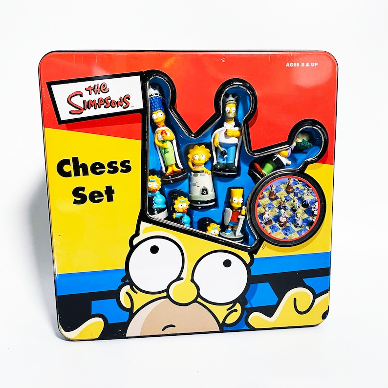May include: A yellow and blue The Simpsons Chess Set in a tin box. The box features a cartoon image of Bart Simpson. The chess set includes 16 plastic chess pieces featuring characters from The Simpsons.