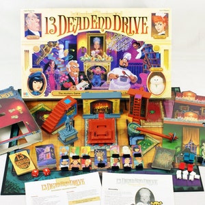 May include: A board game called "13 Dead End Drive" with a colorful box featuring illustrations of characters and a mansion. The game includes a game board, cards, and game pieces.