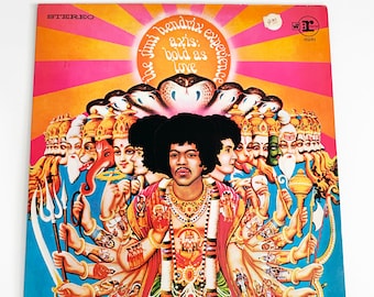 May include: A vintage vinyl record album cover featuring Jimi Hendrix in a colorful, psychedelic design. The album title is "Axis: Bold as Love" and the artist is "The Jimi Hendrix Experience".