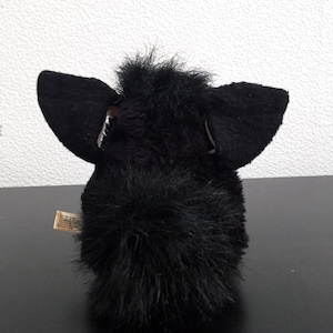 May include: Black furry toy with large ears and a long tail. The toy is made of soft, plush material.