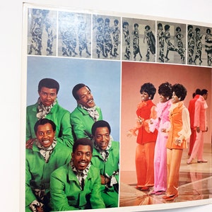 May include: A vintage record album cover featuring a group of six people, four men and two women, dressed in colourful 1970s clothing. The men are wearing green suits with white collars, and the women are wearing pink, orange and red dresses. The album cover has a blue and white background.