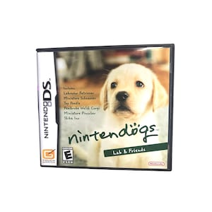 May include: Nintendo DS game cartridge for Nintendogs Lab & Friends. The game features a Labrador Retriever puppy on the cover. The text "Includes: Labrador Retriever, Miniature Schnauzer, Toy Poodle, Pembroke Welsh Corgi, Miniature Pinscher, Shiba Inu" is listed on the left side of the cover.
