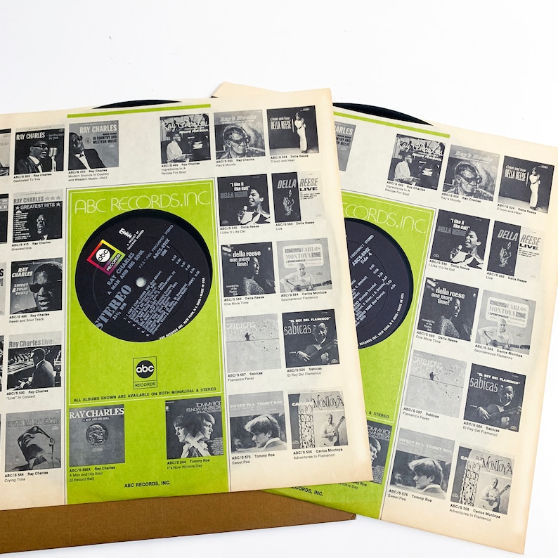 Pu&ograve; includere: Tre album di dischi in vinile vintage con copertine con Ray Charles e altri artisti. Le copertine sono bianche con accenti verdi e neri, che mostrano l'artwork e il testo dell'album. I dischi sono neri.
